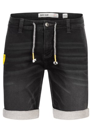 Schwarze Denim-Shorts mit gedämpftem Saum, weißen Zickzack-Zugbändern und einem gelben Etikett auf der linken Seite sowie einem Standardknopfverschluss.