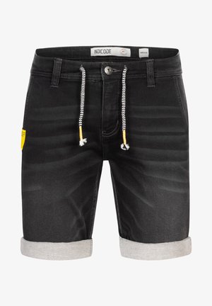 Zwarte denim shorts met een opgerolde zoom, witte zigzag koorden, en een gele label aan de linkerkant met een standaard knoopsluiting.