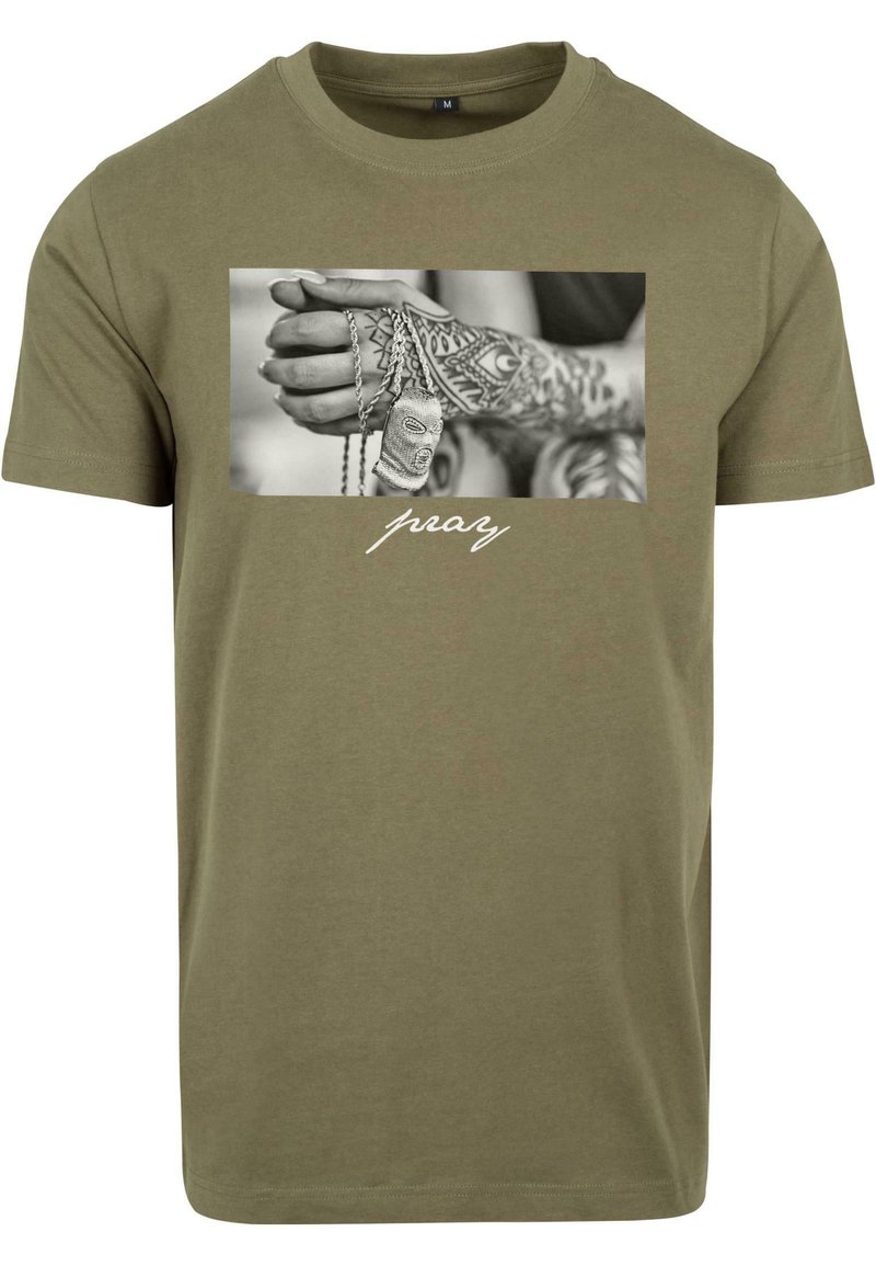 Olive green cotton t-shirt featuring a black-and-white graphic of a hand with tattoos holding dog tags, with the word “pray” in white script below.