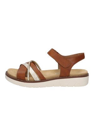 Brown leather sandal featuring crisscross straps, a gold accent band, adjustable back strap, and a white, cushioned sole.