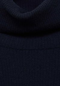 Donker marineblauwe ribgebreide stof met een opgestikte col, die textuur en fijne stikdetails toont.