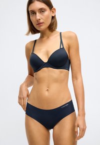 Set de sutien și chiloți de culoare bleumarin închis, din material neted, cu suport cu sârmă și detaliu cu logo pe bandă; bretelele ajustabile îmbunătățesc potrivirea.