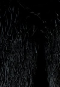 Schwarzer Kunstpelzstoff mit langen, flauschigen Fasern, der eine strukturierte Oberfläche schafft. Das Gesamtbild ist dicht und weich, geeignet für Oberbekleidung.