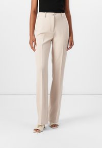 Beige tailored trousers with a straight-leg design, featuring a front zipper and button closure. Smooth fabric with minimal texture.