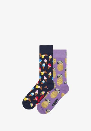 Two pairs of socks: one navy with colorful ice cream cones, and one lavender with pineapples. Both have "HAPPY" printed in black.