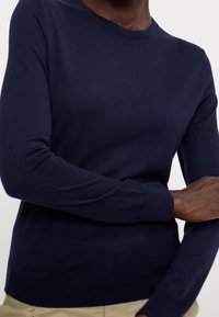 Maglione a manica lunga blu navy in un morbido tessuto a maglia, con scollatura a girocollo e polsini a coste, dal fit rilassato.