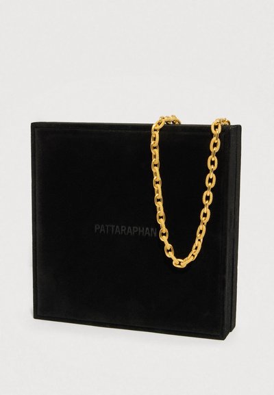 Geantă dreptunghiulară neagră cu curea din lanț texturat auriu atârnând peste partea de sus, pe un fundal simplu și deschis la culoare.