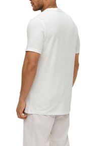 Witte kortekous t-shirt van zachte stof, met een ronde hals en een iets loose fit, weergegeven vanuit de achterkant met minimale details.