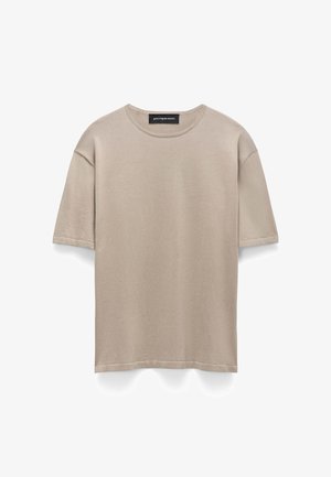 Beige short-sleeve cotton T-shirt with crew neck and visible brand label inside collar, displayed on white background.