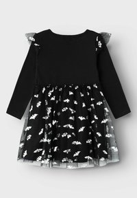 Vestito nero con maniche lunghe, caratterizzato da un corsetto aderente e una gonna in tulle a strati decorata con motivi di pipistrello bianchi e dettagli arricciati.