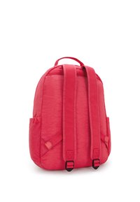 Röd tygryggsäck med justerbara vadderade remmar, två sidofickor, ett rundat topp och en strukturerad yta. Har svarta hårdvaru-accenter.