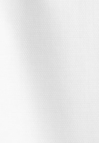 Tissu blanc texturé avec un motif tissé subtil créant un effet d’ombre diagonale douce sur la surface.