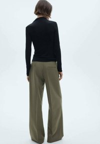 Black long-sleeve top and olive wide-leg trousers, featuring a fitted silhouette, smooth texture, and minimalistic design.