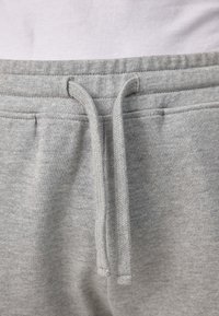 Graue Sweatpants mit einem Kordelzugbund, weicher Textur und elastischer Taille, im einfachen Design ohne sichtbare Muster.