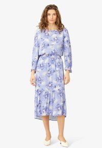 Rochie florală de culoare albastru deschis, cu talie elastică, mâneci lungi și fustă în straturi. Fabricată dintr-un material moale, cu modele de flori violet și roz.