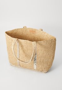 Bolsa de mano de paja tejida en color beige, con un exterior texturizado, dos asas y rayas metálicas en la parte frontal.