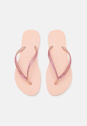 Infradito rosa in gomma con cinturini glitterati e suola testurizzata. Presentano un logo su un cinturino. Adatti per un abbigliamento casual.