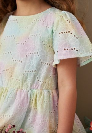 Robe aux couleurs pastel avec un motif en dentelle florale, manches courtes bouffantes et taille froncée. Le tissu semble léger et aérien.