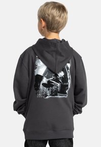 Donkergrijze hoodie met een grafische print van een skateboardscene en het jaar "1994" herhaald in het wit. Gemaakt van zware katoenmix.