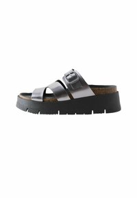 Sandales à plateforme noires avec des brides croisées en métal argenté, boucle ajustable, semelle en liège et semelle extérieure en caoutchouc texturé.