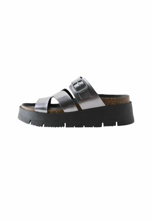 Black platform sandals with metallic silver cross straps, adjustable buckle, cork footbed, and textured rubber outsole.