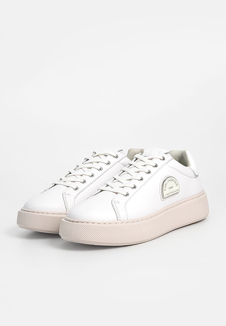 Zapatillas blancas de cuero con puntera redondeada, diseño con cordones y suela de goma gruesa. Presentan un parche con el logo en el lateral y ojales plateados.