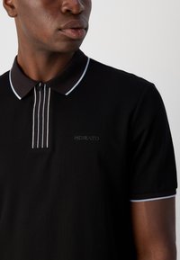 Polo noir avec un col classique, présentant des accents rayés bleus sur la patte de boutonnage et les poignets, et un logo "Morato" subtil sur la poitrine.