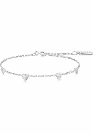 Bracciale delicato con catena d'argento e quattro piccoli ciondoli a forma di cuore, uno impreziosito da cristalli, e chiusura regolabile con targhetta del marchio.