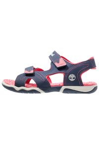 Navy and pink sandals with two adjustable straps, cushioned pink insole, open sides, textured rubber sole, and logo detail on the side.