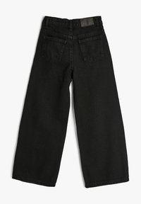 Sorte denim jeans med bred benvidde og høj talje, fem lommer og synlig syning. Stoffet ser slidstærkt ud med en glat tekstur.