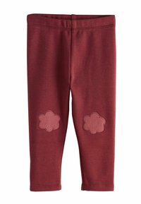 Bordowe legginsy wykonane z miękkiego materiału z elastycznym pasem. Posiadają dwa różowe łatki w kształcie kwiatów na każdym kolanie. Gładka tekstura.