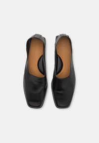 Zwarte leren schoenen met een vierkant teendesign, voorzien van open zijkanten en een gladde textuur. De binnenzool is bruin met reliëf branding.