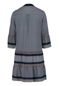 Mörkblå och vit mönstrad knälång klänning med 3/4-långa ärmar, orangea detaljer och horisontella dekorativa band nära fållen och ärmarna.