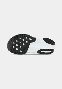 Semelle de chaussure avec un extérieur en caoutchouc noir texturé, présentant un motif géométrique blanc et une semelle intermédiaire blanche solide pour une adhérence et une stabilité accrues.