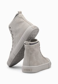 Hoge sneakers gemaakt van lichtgrijs suede met een gestructureerde rubberen zool, voorzien van ton-sur-ton stiksels en een trekriem op de hiel.