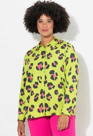 Groene luipaardprint shirt met zwarte en roze details, knoopsluiting, lange mouwen en een kraag. Glad stofoppervlak.