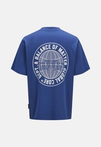 Blå bomulds t-shirt med et stort hvidt grafisk print af et globusdesign og tekst på ryggen. Kortærmet og rund halsudskæring.
