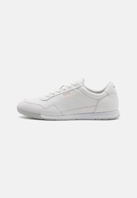 Hvit sneakers med glatt skinnoverdel, teksturerte detaljer og sømmer. Har snøring foran og gummisåle med grep mønster.