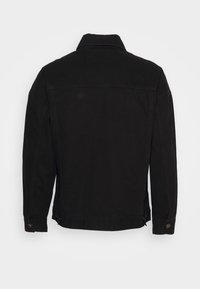 Veste en denim noir avec col, manches longues et poignets à boutons. Présente un design à coupe droite et un minimum de coutures au dos.