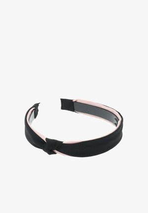 Czarna opaska na głowę z materiału z supełkowym wzorem, z miękkim różowym wnętrzem. Kształt jest płaski i zaokrąglony, odpowiedni do stylizacji włosów.