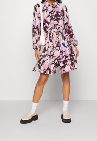 Mehrfarbiges Kleid mit einem Druck aus pinken, braunen und blauen Pinselstrichen, mit Kragen, langen Ärmeln und elastischem Bund.