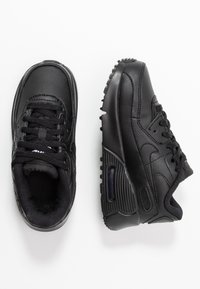 Μαύρα δερμάτινα αθλητικά παπούτσια με υφή, διαθέτουν επενδυμένο κολάρο, κούμπωμα με κορδόνια και ορατή μονάδα αερόσολας στην σόλα.