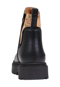 Botín de cuero negro con un interior texturizado y estampado, y una suela de goma gruesa. Presenta un acabado suave y acentos en relieve.