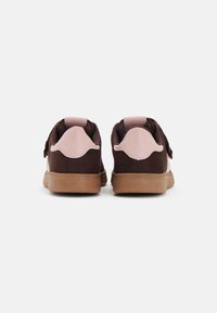 Braune Wildledersneaker mit pinken Akzenten. Verfügt über ein rundes Design, eine flache Gummisohle und eine weiche Fersenlasche. Die Rückansicht zeigt ein einzigartiges Stichdetail.