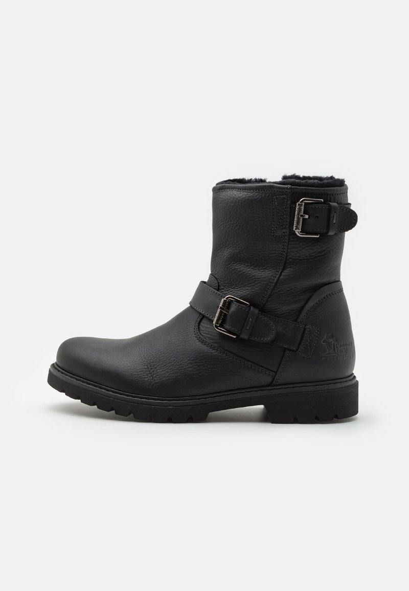 Schwarze Leder-Stiefeletten mit strukturiertem Finish, ausgestattet mit einem Schnallenriemen und einer robusten Gummisohle. Innen mit weichem Material ausgekleidet für zusätzlichen Komfort.