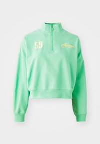 Felpa cropped verde menta con colletto alto, zip a quarto di lunghezza e logo giallo ricamato. Presenta polsini e bordo in costina.