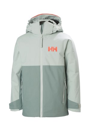 Chaqueta de color verde claro con una sección inferior en verde más oscuro. Presenta un cuello alto, cierre con cremallera en la parte delantera, dos bolsillos laterales y un logo naranja.