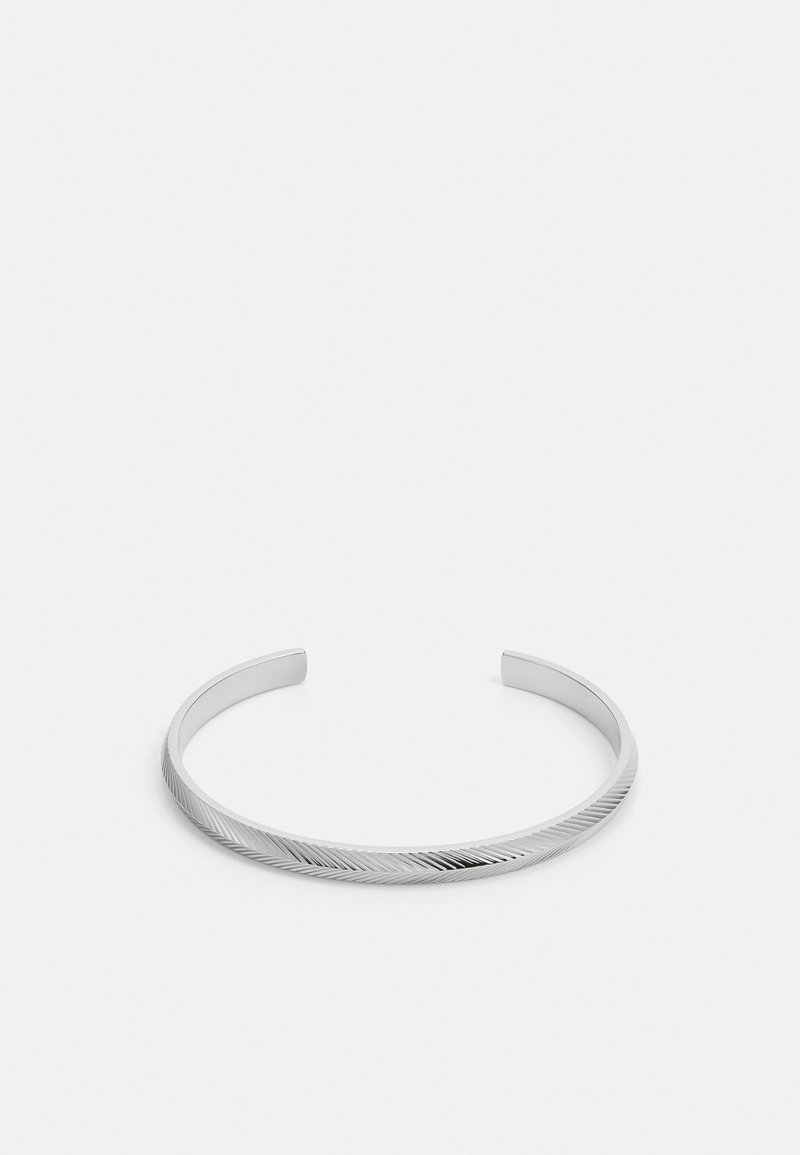 Sølv armring med et slankt design, der har et struktureret diagonalt mønster og glatte kanter, lavet af poleret metal.