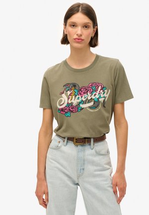T-shirt en coton vert olive avec un design coloré brodé de fleurs et d'un serpent, avec le texte "Superdry" en police cursive.