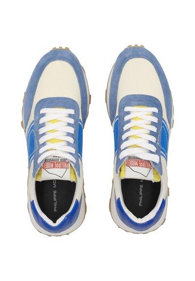 Sneaker blu e bianche in materiali scamosciati e tessili, con accenti gialli a contrasto, lacci piatti e suola in gomma con marchio stampato.